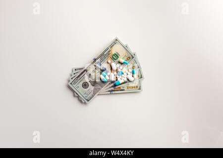Pharmazeutische Unternehmen Konzept. Bargeld und Pillen auf weißem Hintergrund Stockfoto