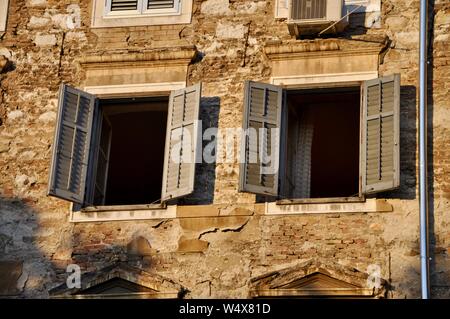 Alte open Fensterläden aus Holz auf zerstörten Haus mit mediterranem Charme Stockfoto