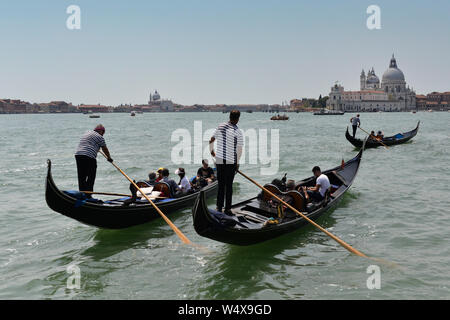 Touristen während einer Gondelfahrt auf dem Canale della Giudecca/Canale di San Marco mit der Punta della Dogana im Hintergrund. Venedig, Venetien, Italien Stockfoto