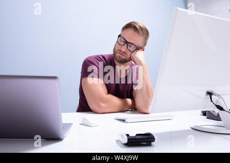 Erschöpft, Geschäftsmann, Schlafen auf dem Schreibtisch vor dem Computer im Büro Stockfoto