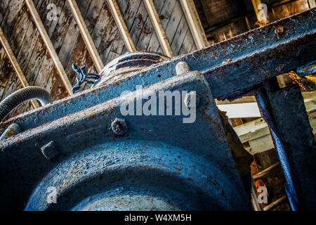 Detail des alten verrosteten Maschinen und Schrauben mit Peeling blaue Farbe unter Holzdecke. Stockfoto