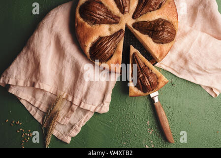 Soft Cake mit ganzen Birnen auf einem Küchenpapier. Oben Ansicht mit einer geschnittenes Obst Torte. Einzige Scheibe Obstkuchen Stockfoto