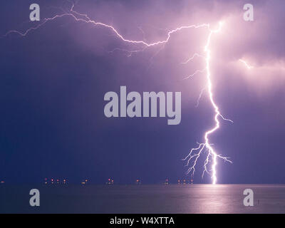 Münster am Meer, Kent, Großbritannien. 25. Juli, 2019. UK Wetter: Blitz über Münster am Meer in Kent gesehen. Im Bild: blitzschläge direkt rechts neben der Windpark Kentish Flats. Credit: James Bell/Alamy leben Nachrichten Stockfoto