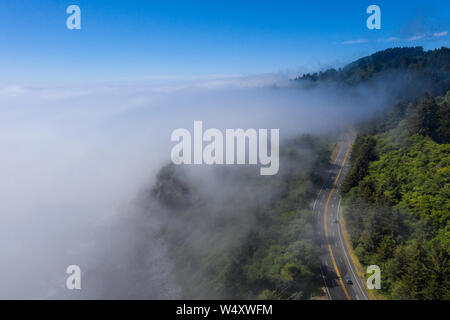 Aus der Vogelperspektive, den nebligen marine Layer sickert über den Pacific Coast Highway, entlang der malerischen Küste in Nordkalifornien läuft. Stockfoto