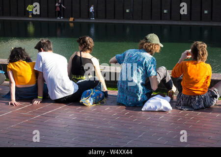 Junge Menschen Abkühlung und Entspannung außerhalb des Barbican Ausstellungs- und Konzerthalle in einer sehr heißen Tag in London, Großbritannien Stockfoto