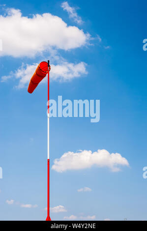 Windsack auf Pole in Breeze gegen den blauen Himmel und Wolken Cumulus. Stockfoto