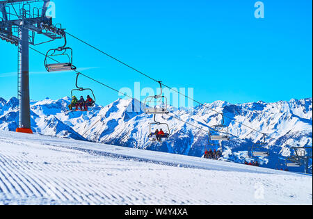 ZELL AM SEE, Österreich - 28. FEBRUAR 2019: schnell laufenden Kabinen von Kapellenbahn Sessellift auf der Oberseite von Snowbound Schmittenhohe Berg, bedeckt mit nume Stockfoto