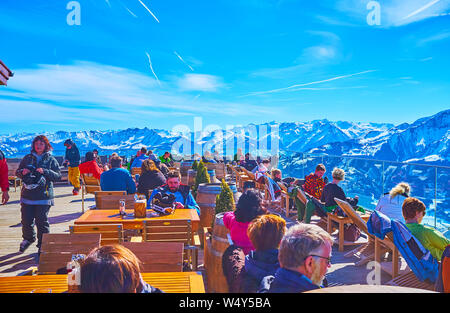 ZELL AM SEE, Österreich - 28. FEBRUAR 2019: Die Skifahrer und andere Sportler genießen Sie die sonnige open air Lounge Restaurant oben auf der Schmitten, Febr. Stockfoto