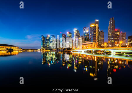 Singapur Hochhaus Gebäude in der Innenstadt mit Wasser Reflexion an der Marina Bay in Nacht, Singapur. Stockfoto