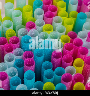 Gruppe von bunten Plastiktrinkstrohhalmen mit Wassertropfen Stockfoto