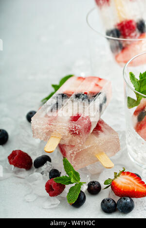 Eis am Stiel Champagner mit Erdbeeren, Himbeeren und Heidelbeeren Stockfoto