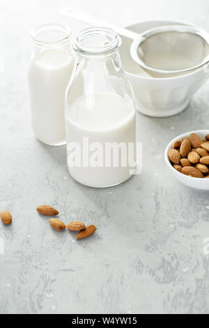 Hausgemachtes Mandel Milch in Glasflaschen mit einem Sieb Stockfoto