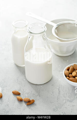 Hausgemachtes Mandel Milch in Glasflaschen mit einem Sieb Stockfoto