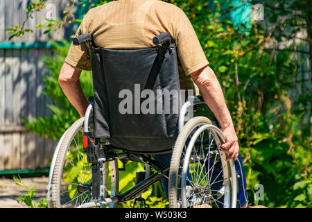 Behinderte ältere Mann in den Vorsitz in der Landschaft Cottage, Elder Krankheit Stockfoto