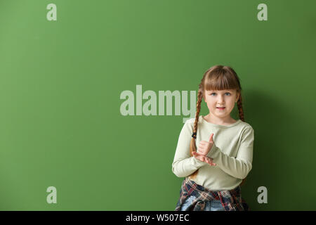 Taubstumme Mädchen mit Gebärdensprache auf Farbe Hintergrund Cute Stockfoto