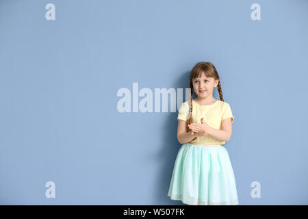 Taubstumme Mädchen mit Gebärdensprache auf Farbe Hintergrund Cute Stockfoto