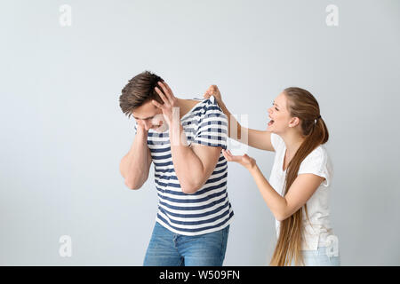 Junge zerstrittenen Paar auf hellen Hintergrund Stockfoto