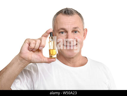 Gut aussehender Mann mittleren Alters mit Flasche Serum für Hautpflege auf weißem Hintergrund Stockfoto