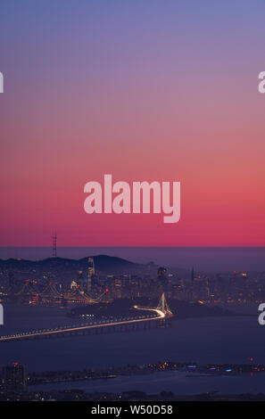 San Francisco Skyline der Stadt bei Sonnenuntergang wie aus über die Bucht mit rosa Himmel gesehen Stockfoto