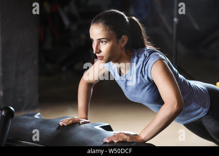 Sportliche junge Frau Training im Fitnessraum Stockfoto