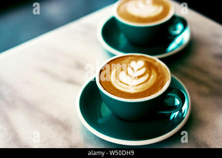 Ein paar Tassen Cappuccino kunst Kaffee mit Schaum in der Form einer Tulpe auf dem Marmor Hintergrund, Platz für Text Stockfoto