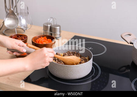 Frau kochen traditionelle Chili con carne in der Küche Stockfoto