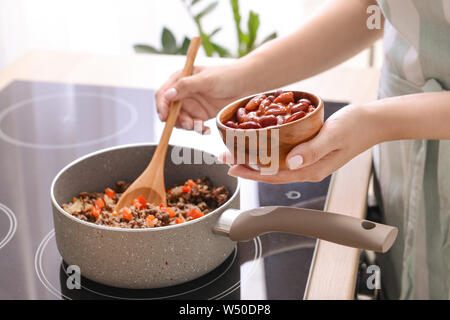 Frau kochen traditionelle Chili con carne in der Küche Stockfoto