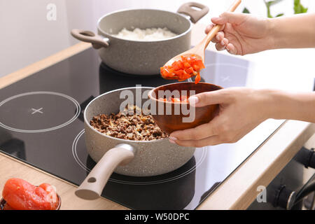 Frau kochen traditionelle Chili con carne in der Küche Stockfoto