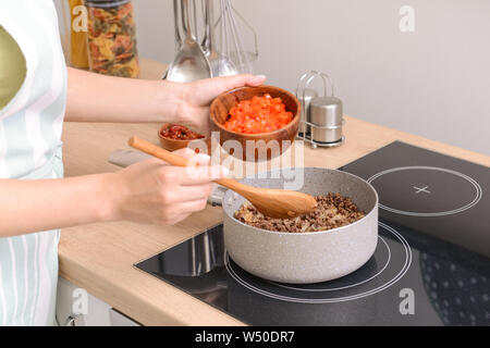 Frau kochen traditionelle Chili con carne in der Küche Stockfoto