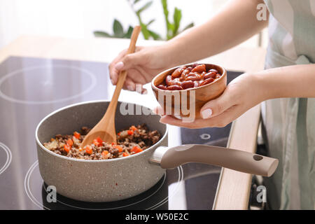 Frau kochen traditionelle Chili con carne in der Küche Stockfoto