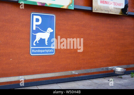 'Dog Parkplatz Station' für Hunde warten auf Besitzer außerhalb der Läden mit blauen Schild mit Hund an der Leine, Haken zum Befestigen von Leine und bewässerungskugeln Stockfoto