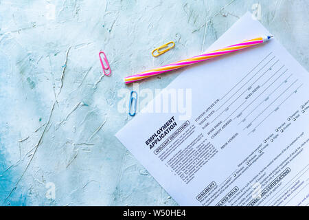 Standard Anwendung für die Beschäftigung. HR, Einstellung, Konzept anwenden. Bewerbungsformular. Ansicht von oben. Bunte Büroklammern und Stift. Stockfoto