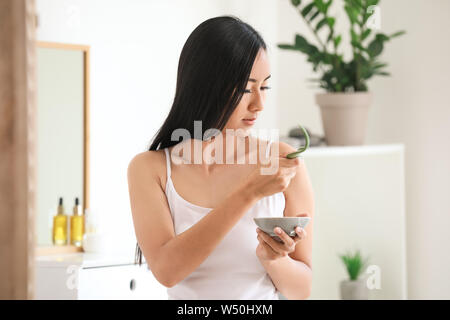 Schöne asiatische Frau mit Aloe vera zu Hause Stockfoto