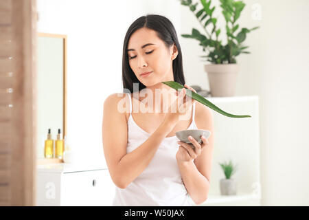 Schöne asiatische Frau mit Aloe vera zu Hause Stockfoto