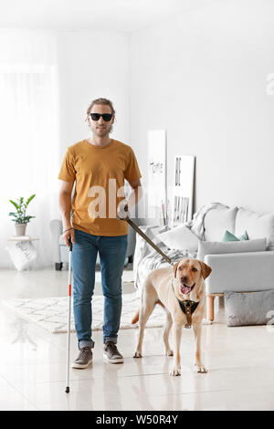 Blinden jungen Mann mit Hund zu Hause Stockfoto