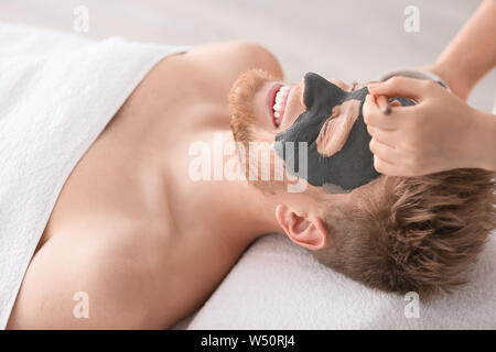 Kosmetiker die Maske auf das Gesicht des Mannes in Spa Salon Stockfoto