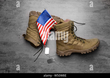 Militärstiefel, USA Flagge und Dog Tags auf grauem Hintergrund Stockfoto