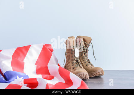 Militärstiefel und USA-Flagge auf Tisch Stockfoto