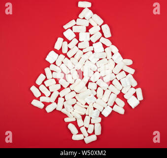Weißen Füllstoff für die Verpackung und den Transport von Waren in der Form eines Weihnachtsbaums verlegt, roter Hintergrund Stockfoto