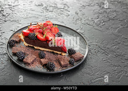Mit der leckeren Schokolade Stück Erdbeertorte auf dunklem Hintergrund Platte Stockfoto