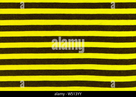 Textur von echten Strickwaren in schwarzen und gelben Streifen, Textil- Hintergrund. Wie eine Biene. Stockfoto