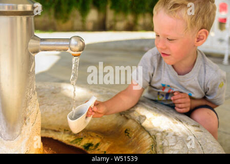 Kleinen Jungen ins Wasser aus heissen Mineralquelle in Karlsbad in speziellen Mug Stockfoto