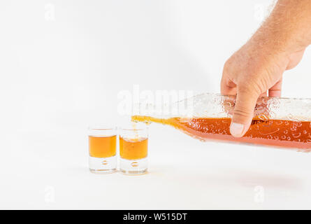Detail eines Menschen Hand Whisky in zwei kleinen Gläsern serviert - Luxuriöse Whiskey Stockfoto