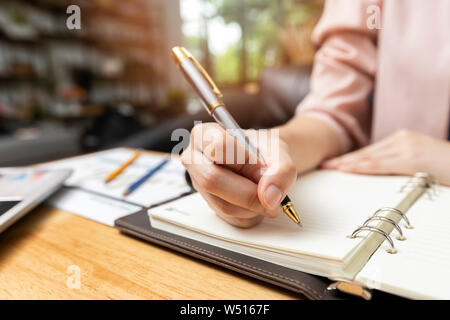 Geschäftsfrau schreiben oder Zeigen auf Bericht Papier. Business Strategie Konzept. Nahaufnahme Geschäftsfrau Notizen im Notebook Stockfoto