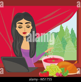 Hausfrau sucht in Laptop beim Kochen Suppe zu Hause Küche Stockfoto