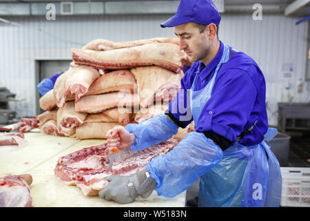 Schneiden von Fleisch im Schlachthof. Die Fleisch- und Wurstfabrik. Stockfoto