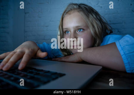 Süßes schulmädchen Kind spielen und online surfen spät in der Nacht. Kind süchtig nach Internet Spiele und Social Media kann nicht auf Laptop Schlaf angespannt. Digita Stockfoto