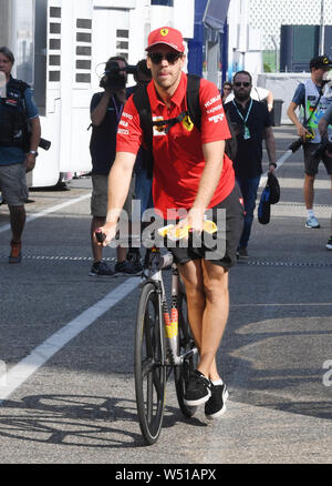 Hockenheim, Deutschland. 26. Juli, 2019. Motorsport: Formel 1-Weltmeisterschaft, den grossen Preis von Deutschland. Sebastian Vettel aus Deutschland vom Team Scuderia Ferrari kommt auf die Koppel mit einem Fahrrad. Credit: Uli Deck / dpa/Alamy leben Nachrichten Stockfoto