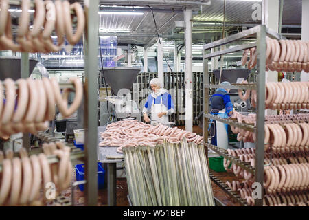 Metzger Verarbeitung Würstchen bei Fleisch Fabrik in einer Fleischfabrik Stockfoto