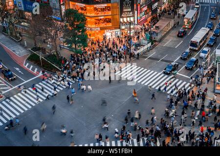 Shibuya Crossing von oben, Massen von Leuten an der Kreuzung mit der Straßenbeleuchtung und farbenfrohe Schilder beleuchtete, beleuchtete Werbung in der Stockfoto